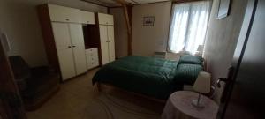 a bedroom with a green bed and a window at Summers Breeze in Nantheuil