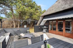 a patio of a house with a thatch roof at 068-Ringkobing-Hvidbjergvej-4 in Søndervig