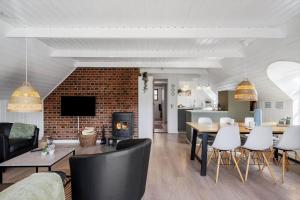 a living room with a fireplace and a table and chairs at 068-Ringkobing-Hvidbjergvej-4 in Søndervig