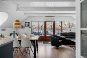 a kitchen and living room with a table and chairs at 068-Ringkobing-Hvidbjergvej-4 in Søndervig
