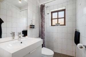 a white bathroom with a sink and a toilet at 068-Ringkobing-Hvidbjergvej-4 in Søndervig +28 photos