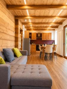 a living room with a couch and a table with chairs at SkyWood Chalet, Panoramic Mountain and Lake Views in Mello