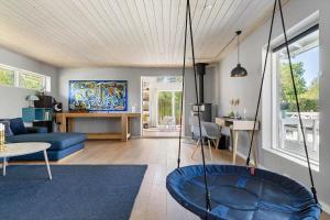 a living room with a blue couch and a swing at 1606-Liseleje-Lisevaenget-18 in Liseleje