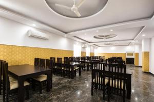 a dining room with tables and chairs and a ceiling at FabHotel Rajvanshi Palace in Gumgaon