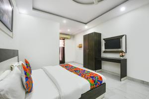 a bedroom with a bed and a television in it at FabHotel Rajvanshi Palace in Gumgaon