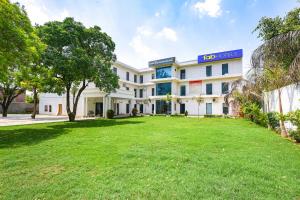 an exterior view of a building with a yard at FabHotel Rajvanshi Palace in Gumgaon