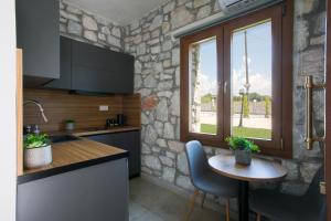 a kitchen with a small table and a window at Nine Muses Hospitality in Nea Irakleia