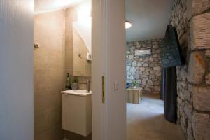 a bathroom with a sink and a stone wall at Nine Muses Hospitality in Nea Irakleia +131 photos