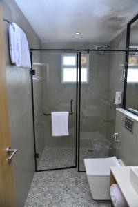 a bathroom with a shower with a toilet and a sink at Vels Grand Hotel in Kanchipuram