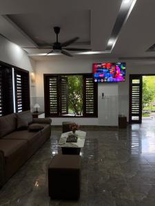a living room with a couch and a flat screen tv at Miu Homestay Hue in Thôn Lại Thê