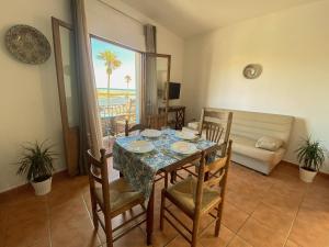 a dining room with a table and chairs and a couch at 1 linea de playa - Apartamentos - Beach & River - Conil in Conil de la Frontera