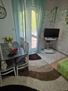 a living room with a table and a television at Eco Bay Montenegro in Donji Morinj