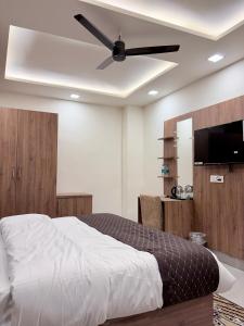 a bedroom with a bed with a ceiling fan at 4 Seasons Residency in Katra