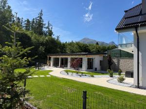 a house with a garden and a fence at Villa White Stone in Starý Smokovec
