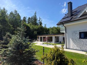 a house with a fence and a yard at Villa White Stone in Starý Smokovec
