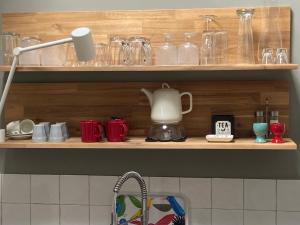 a kitchen shelf with glasses and a coffee pot on it at UNIEK Bommelgaard, guesthouse in het prachtige Rivierenland! in Hurwenen