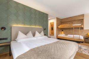 a bedroom with a large white bed in a room at Hotel Garni Romantika in Sankt Leonhard im Pitztal