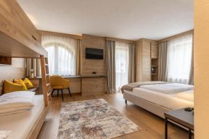 a hotel room with two beds and a television at Hotel Garni Romantika in Sankt Leonhard im Pitztal