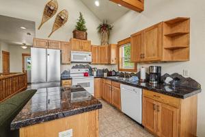 a large kitchen with wooden cabinets and white appliances at Jackstraw Mountain 32 in Estes Park