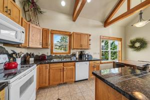 a large kitchen with wooden cabinets and white appliances at Jackstraw Mountain 32 in Estes Park