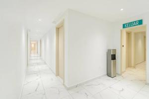 a hallway with white walls and a sign on a wall at Hotel Sunjoy9 Bandar Sunway in Petaling Jaya