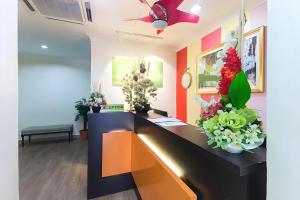 a room with a desk with flowers on it at Hotel Sunjoy9 Bandar Sunway in Petaling Jaya