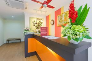 an office with a reception desk with flowers on it at Hotel Sunjoy9 Bandar Sunway in Petaling Jaya