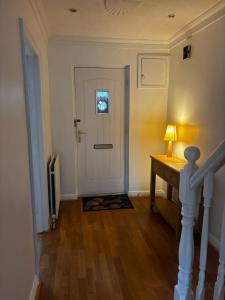 a hallway with a white door and a desk with a lamp at Dublin 12 house in Dublin +2 photos
