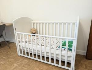 a white crib in a room with a teddy bear at Appartamento La Finestra sul Borgo in Santarcangelo di Romagna