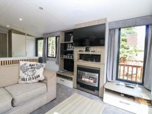 a living room with a couch and a flat screen tv at Wild Duck Holiday Park in Belton
