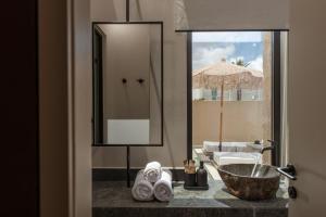 ein Badezimmer mit Waschbecken und Spiegel in der Unterkunft Socrates Hotel & Villas Malia Beach in Malia + 73 Fotos