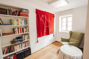 a living room with a chair and a red flag at Geigenhof in Neudorf bei Ilz