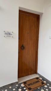 a wooden door with a welcome mat in front of it at Porto Marina SeaView in Porto Rafti