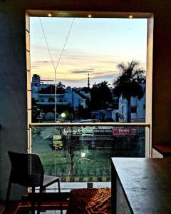 a view of a city from a large window at Hotel heena in Bīr