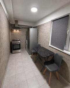 a small kitchen with a table and a refrigerator at Nicolle Elite Apartment in Piteşti +1 photo