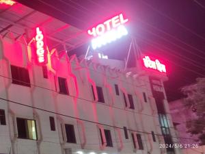 a building with neon signs on top of it at Hotel heena in Bīr