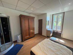 a bedroom with a large bed and a wooden cabinet at Le Clair Briare T2 charmant in Briare