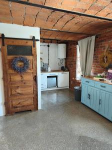 a kitchen with a wooden door in a room at Studio Lawendowe Ranczo in Zawichost