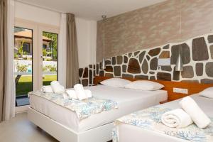 a bedroom with two beds and a large window at Porto Marina in Chrysi Ammoudia +200 photos