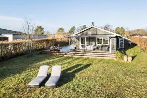 a house with two benches sitting in the grass at 30189-Malling-Fjordvej-52 in Malling