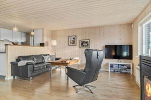 a living room with a leather chair and a couch at 30189-Malling-Fjordvej-52 in Malling