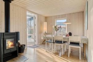 a dining room with a fireplace and a table with chairs at 30189-Malling-Fjordvej-52 in Malling