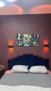 a bedroom with a bed with two paintings on the wall at Çankaya Otel in Altındağ