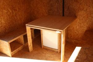 a small wooden table with a window in a room at Eco-Bivouac in La Tagnière