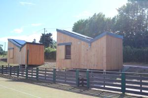 two small wooden buildings next to a fence at Eco-Bivouac in La Tagnière