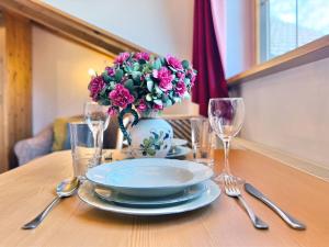 a table with a plate and a vase with purple flowers at Sonnenhof Seeg 15 in Seeg