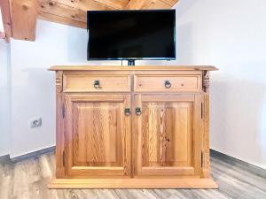a flat screen tv on top of a wooden cabinet at Sonnenhof Seeg 15 in Seeg