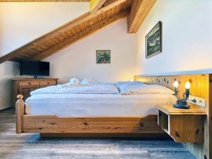 a bedroom with a large bed and a tv at Sonnenhof Seeg 15 in Seeg +12 photos
