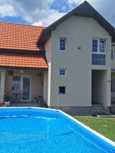 a house with a swimming pool in front of a house at Apartman ISKRA in Mataruška Banja