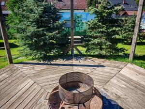 a grill on a wooden deck with two trees at Glamping Langus in Topolšica +54 photos